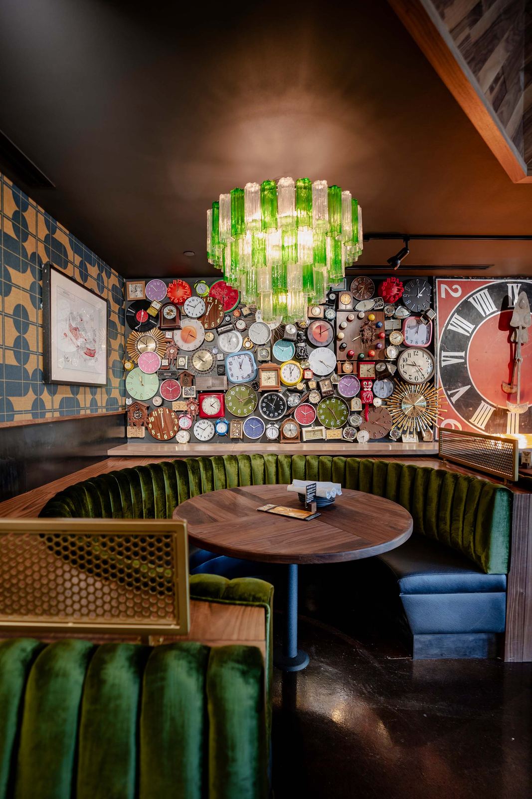 Restaurant booth under a green glass chandelier