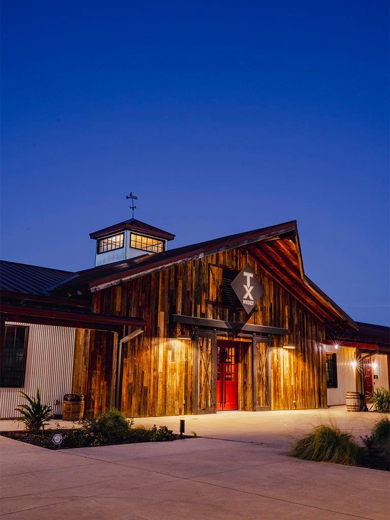 Barn-style distillery exterior at dusk