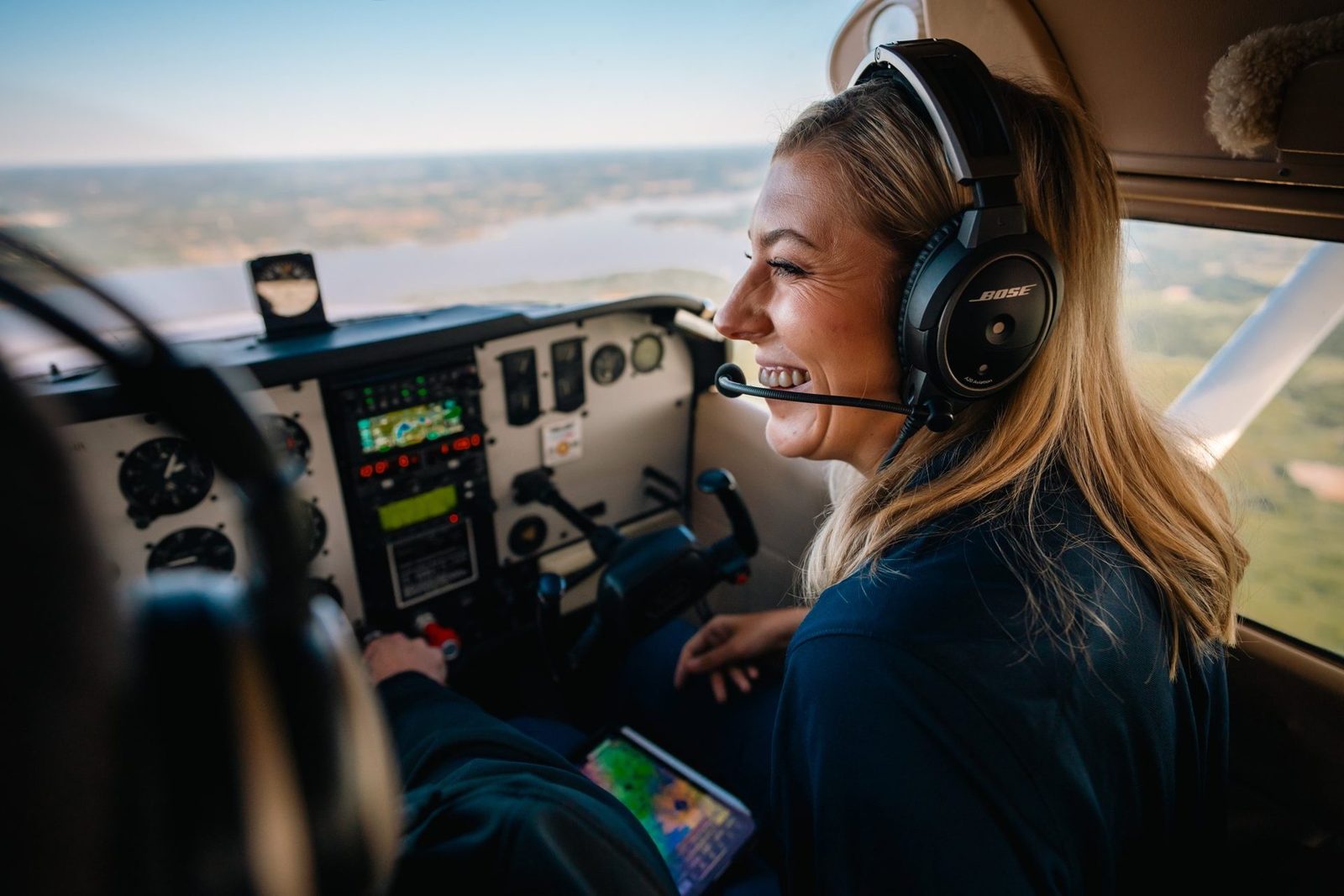 Student pilot laughing in her headset over the lake