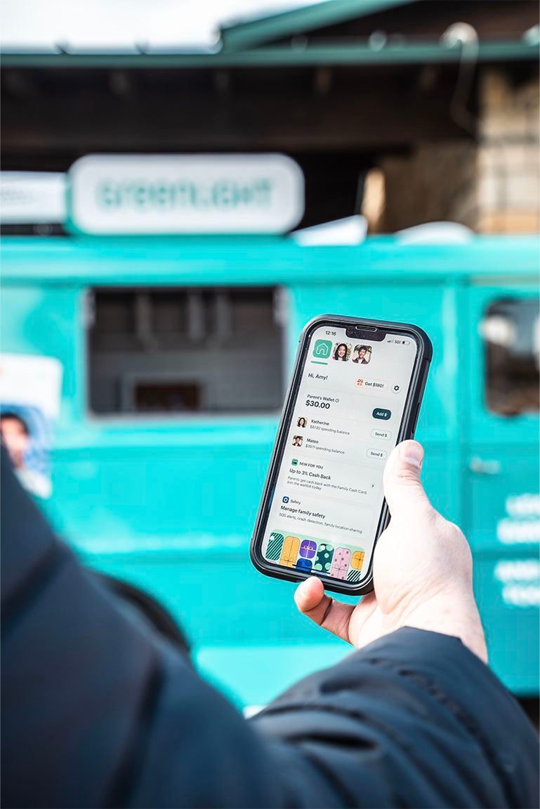 Customer using a fintech app in front of a branded truck