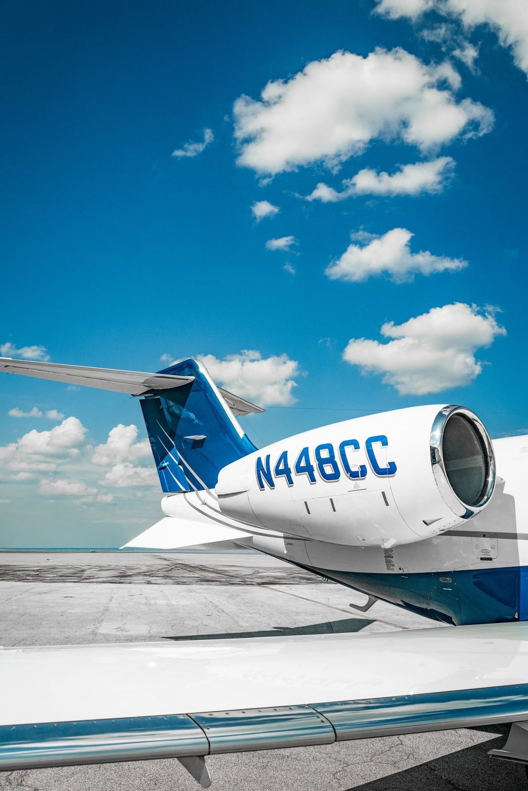 Private jet tail and engine against a blue sky