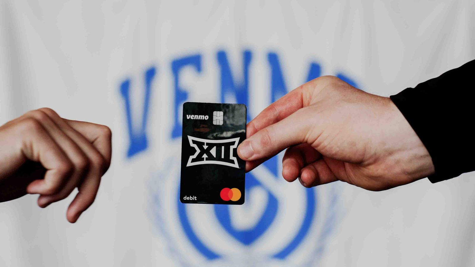 Hands exchanging a Venmo card at a game day activation