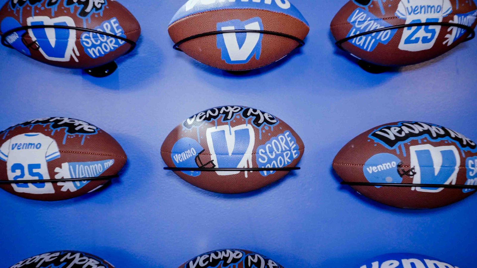 Wall of custom Venmo footballs at a brand activation