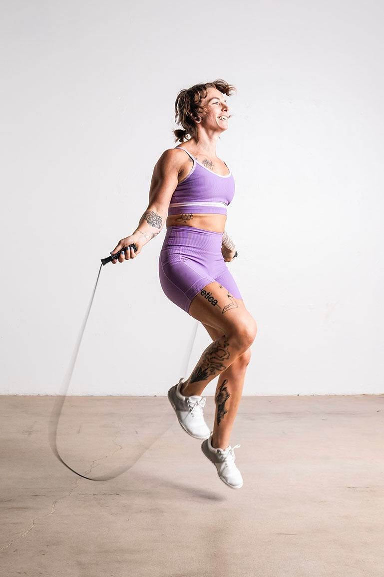Athlete jumping rope in lavender activewear