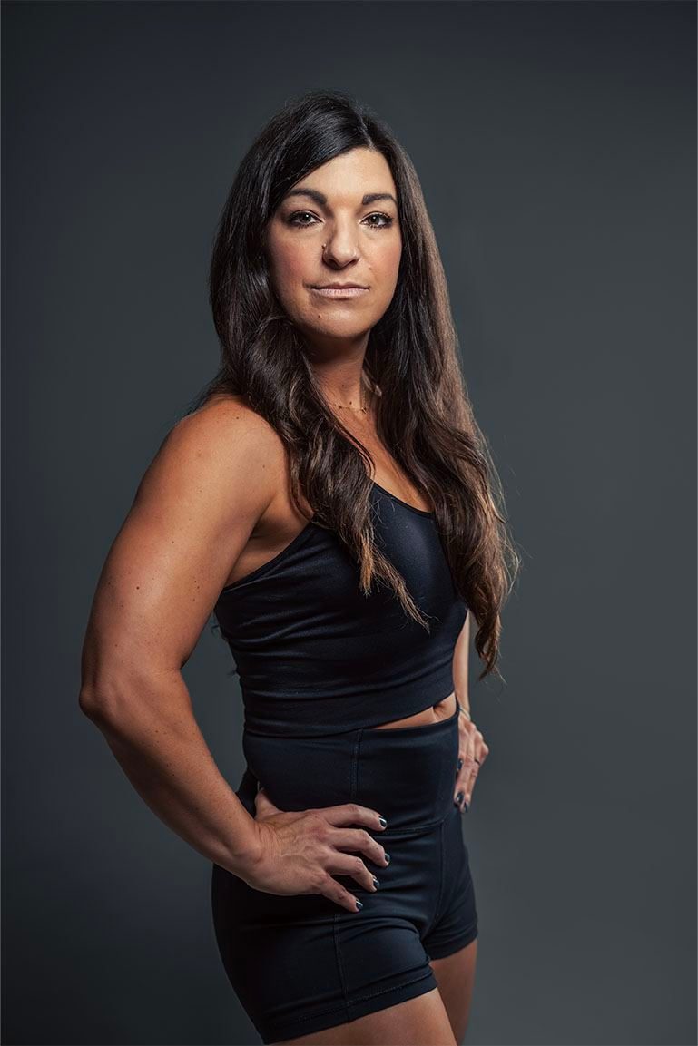 Athlete in black activewear on a dark backdrop