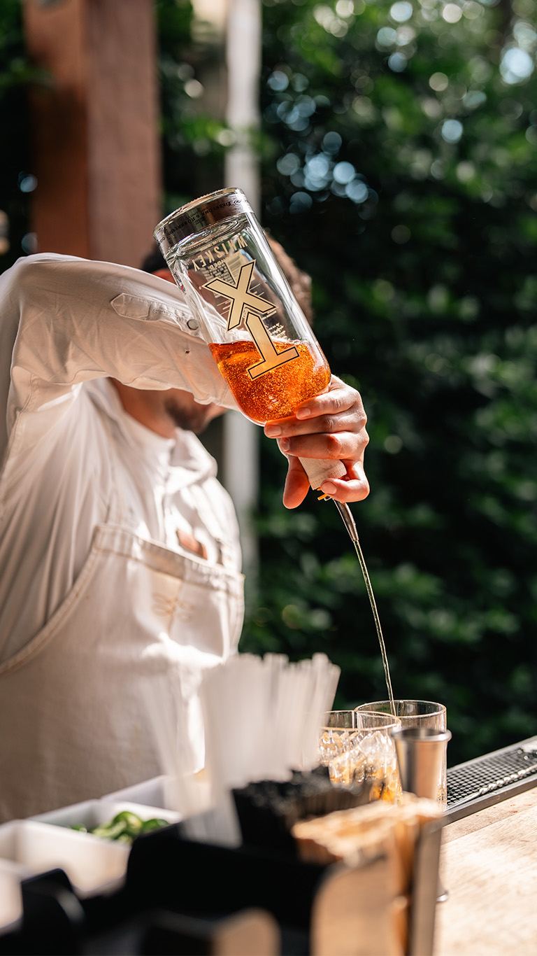 Bartender pouring whiskey into a shaker