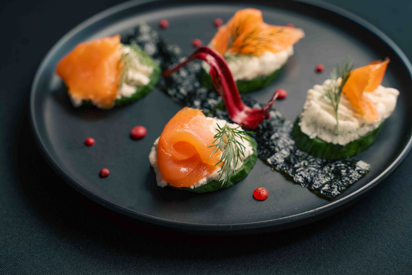 Smoked salmon canapés on a dark plate