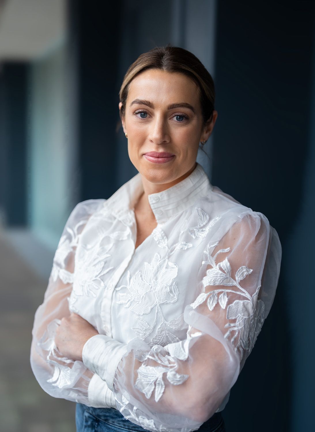 Executive headshot of a woman in a white lace blouse