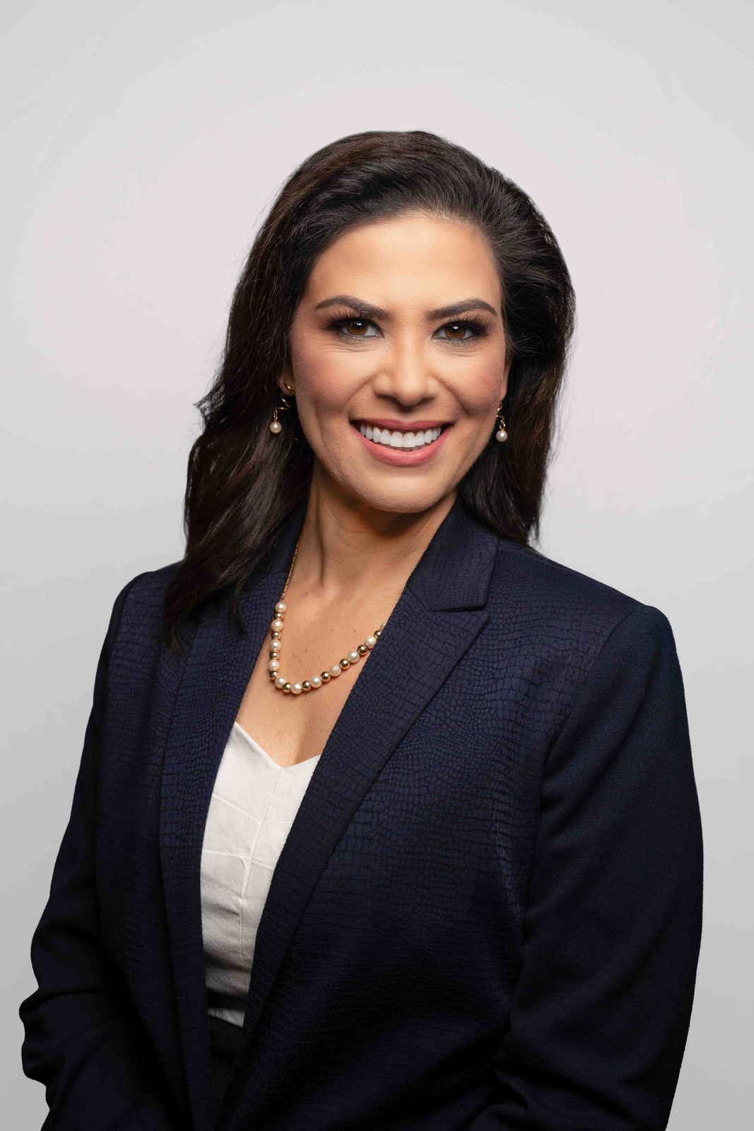 Studio headshot of a woman in a dark blazer