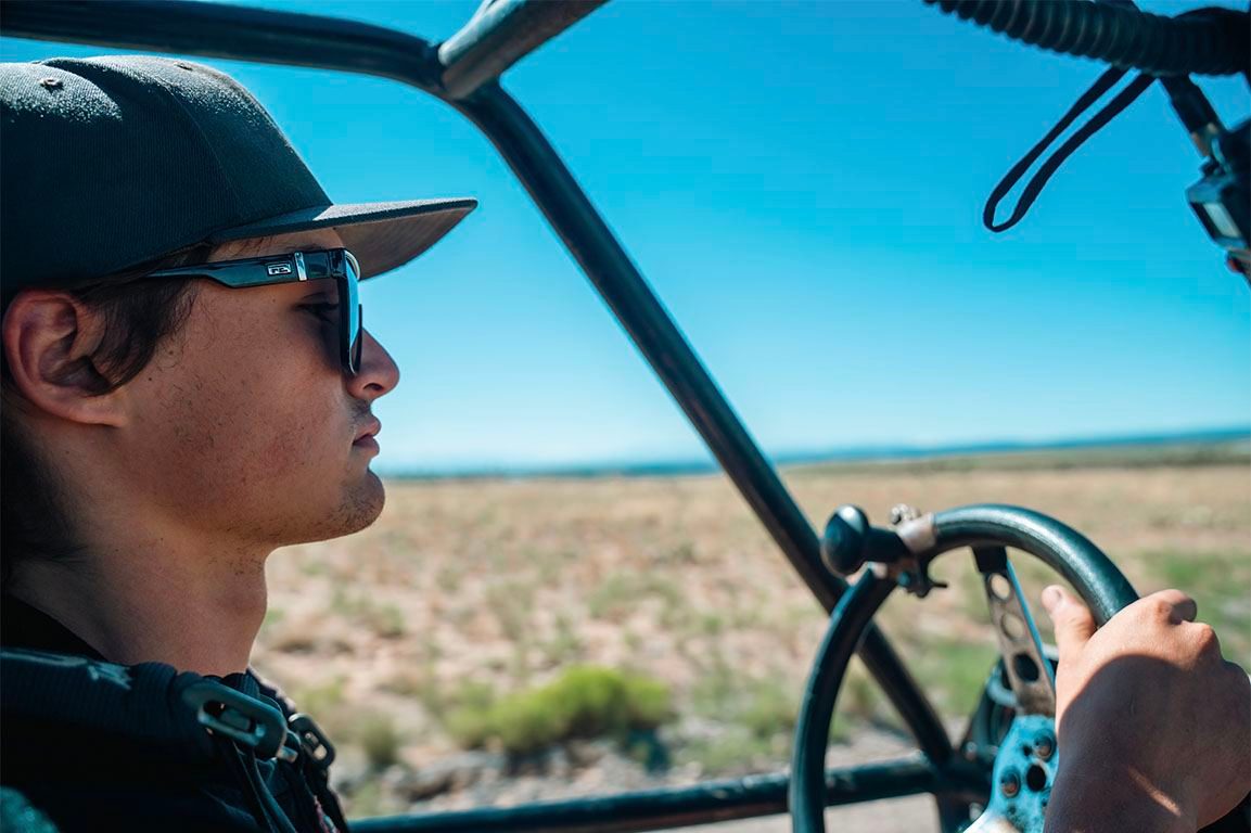 Driver steering an off-road vehicle across the desert