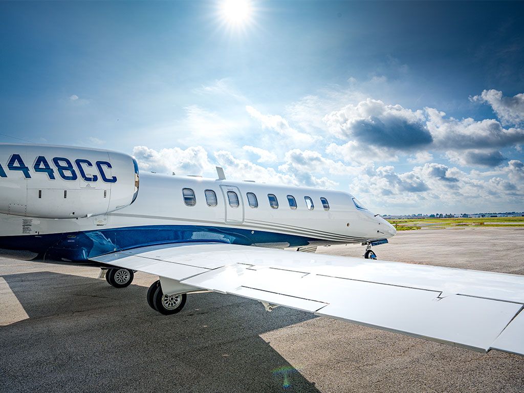 Private jet on the tarmac under a bright sky