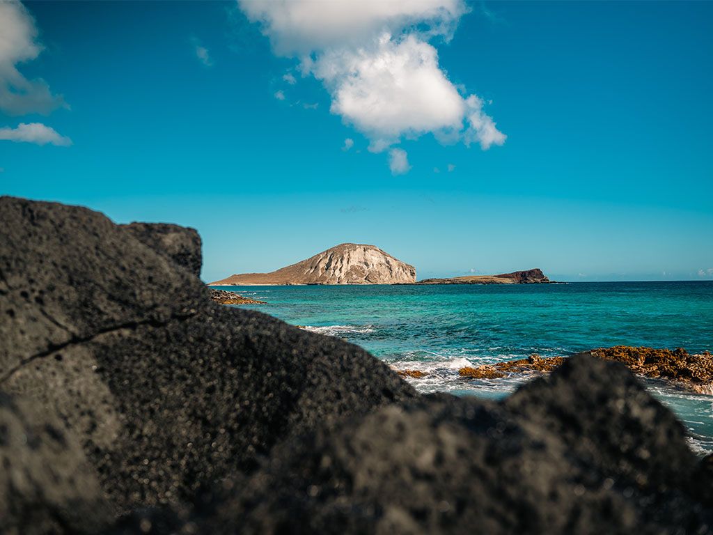 Volcanic rock coastline with an island offshore in Hawaii