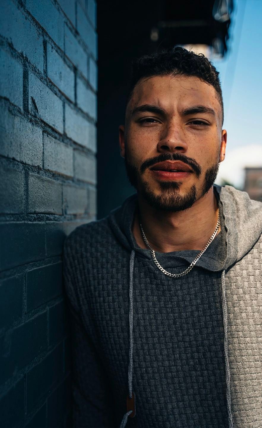 Close portrait of a man against a dark brick wall