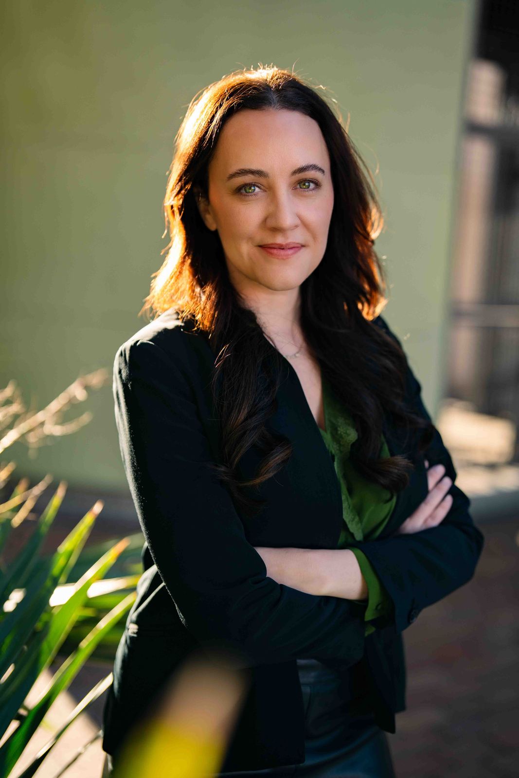 Woman with arms crossed in warm outdoor light