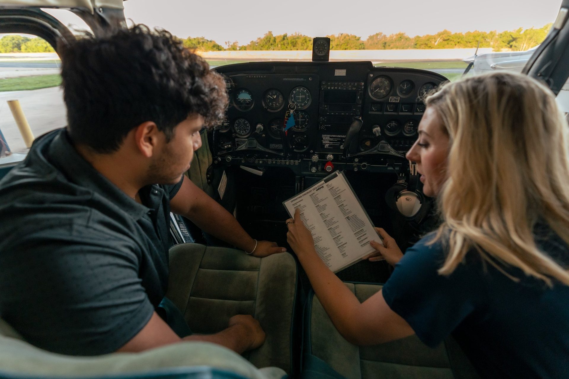 Student and instructor reviewing a checklist in the cockpit