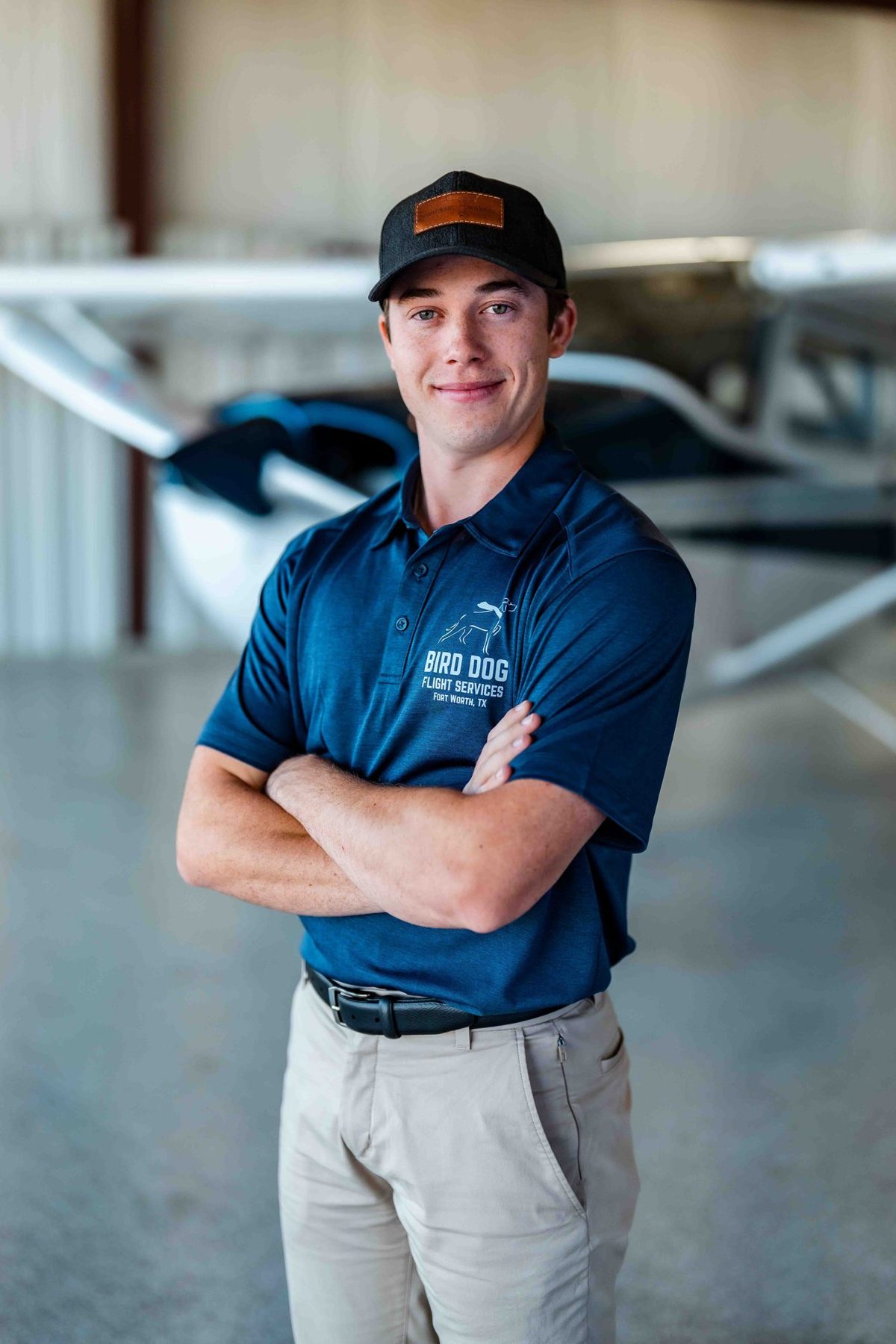Flight instructor in a cap and polo in the hangar