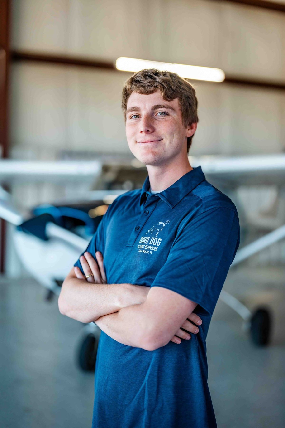 Young pilot in a Bird Dog polo in the hangar