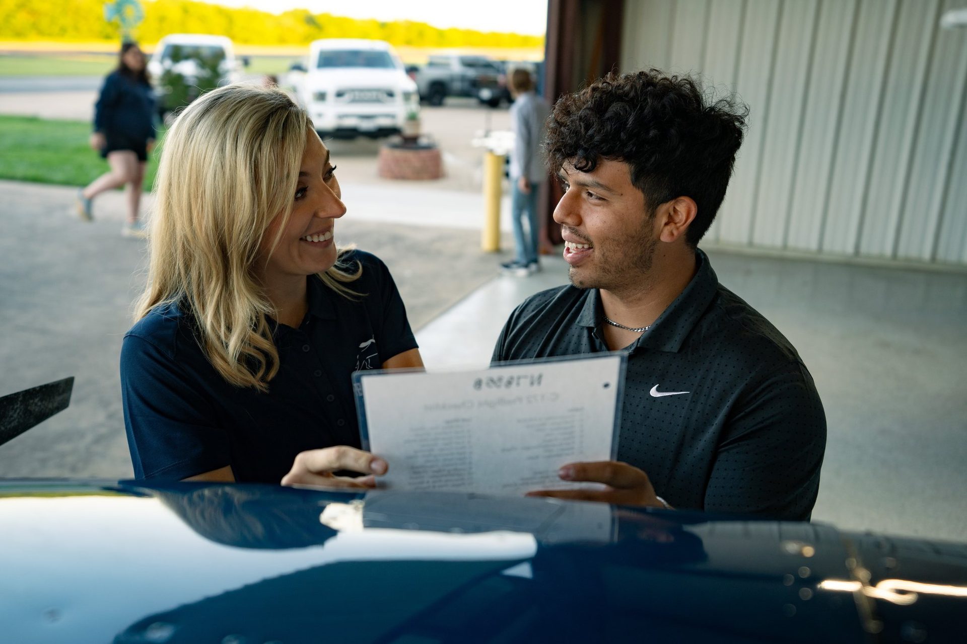 Instructor going over a checklist with a student by the plane