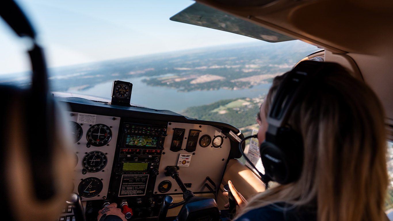 View over a student pilot's shoulder toward the instrument panel in flight