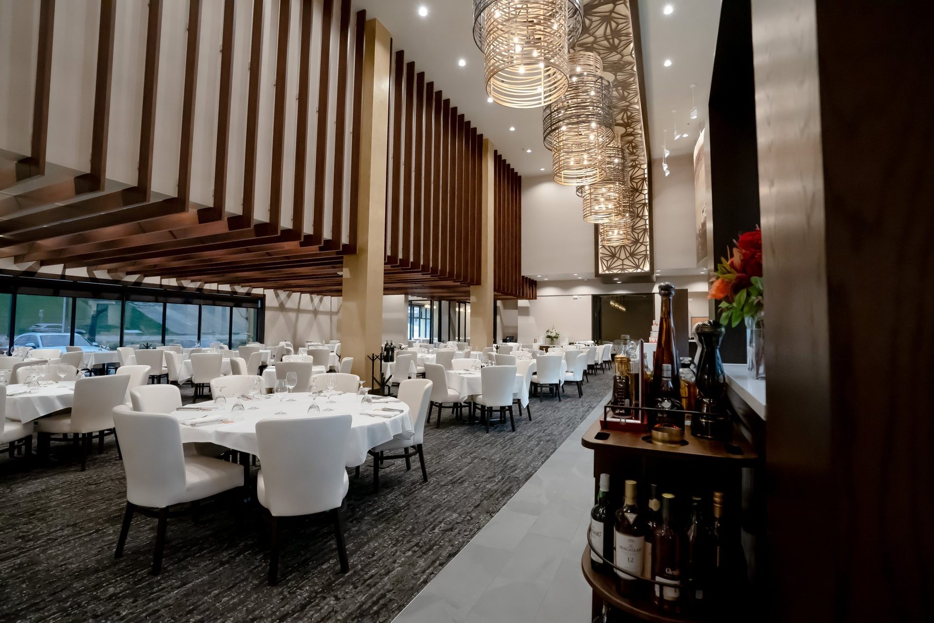 Dining room with white chairs and tall windows