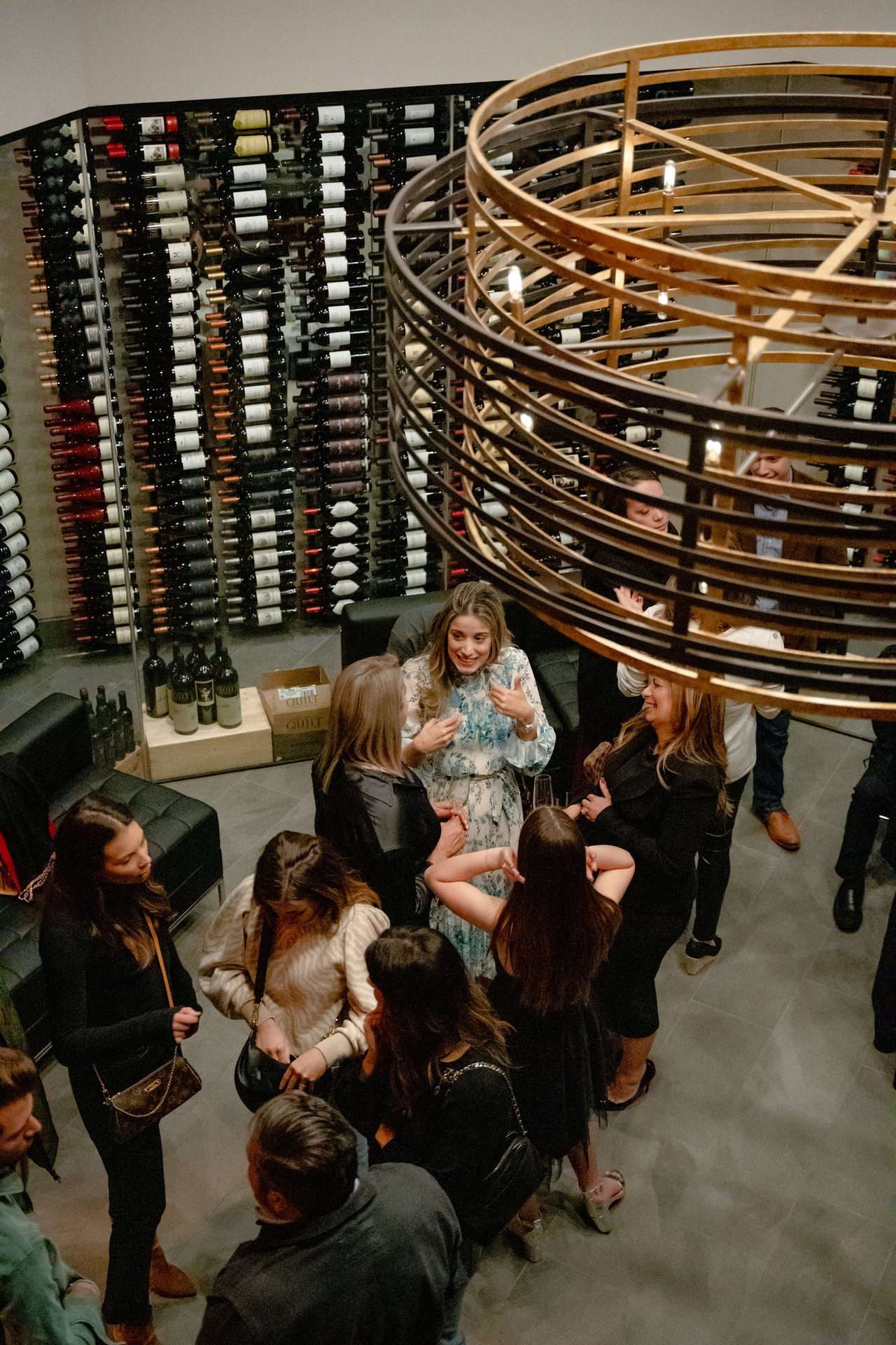 Guests mingling under the wine room chandelier