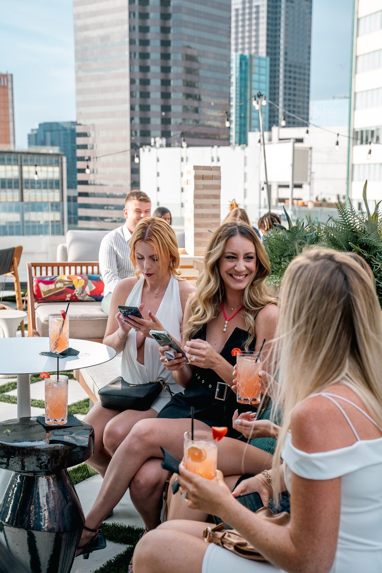 Friends sharing cocktails with the skyline behind