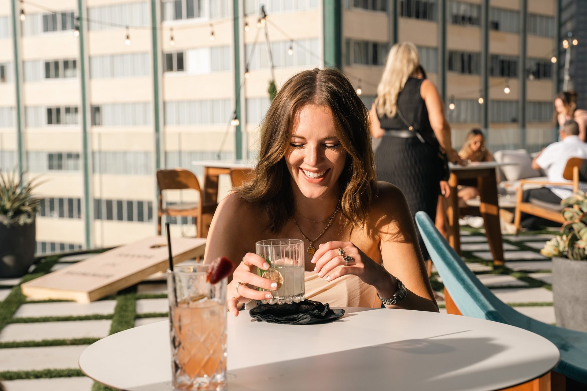 Guest laughing with a cocktail on the rooftop