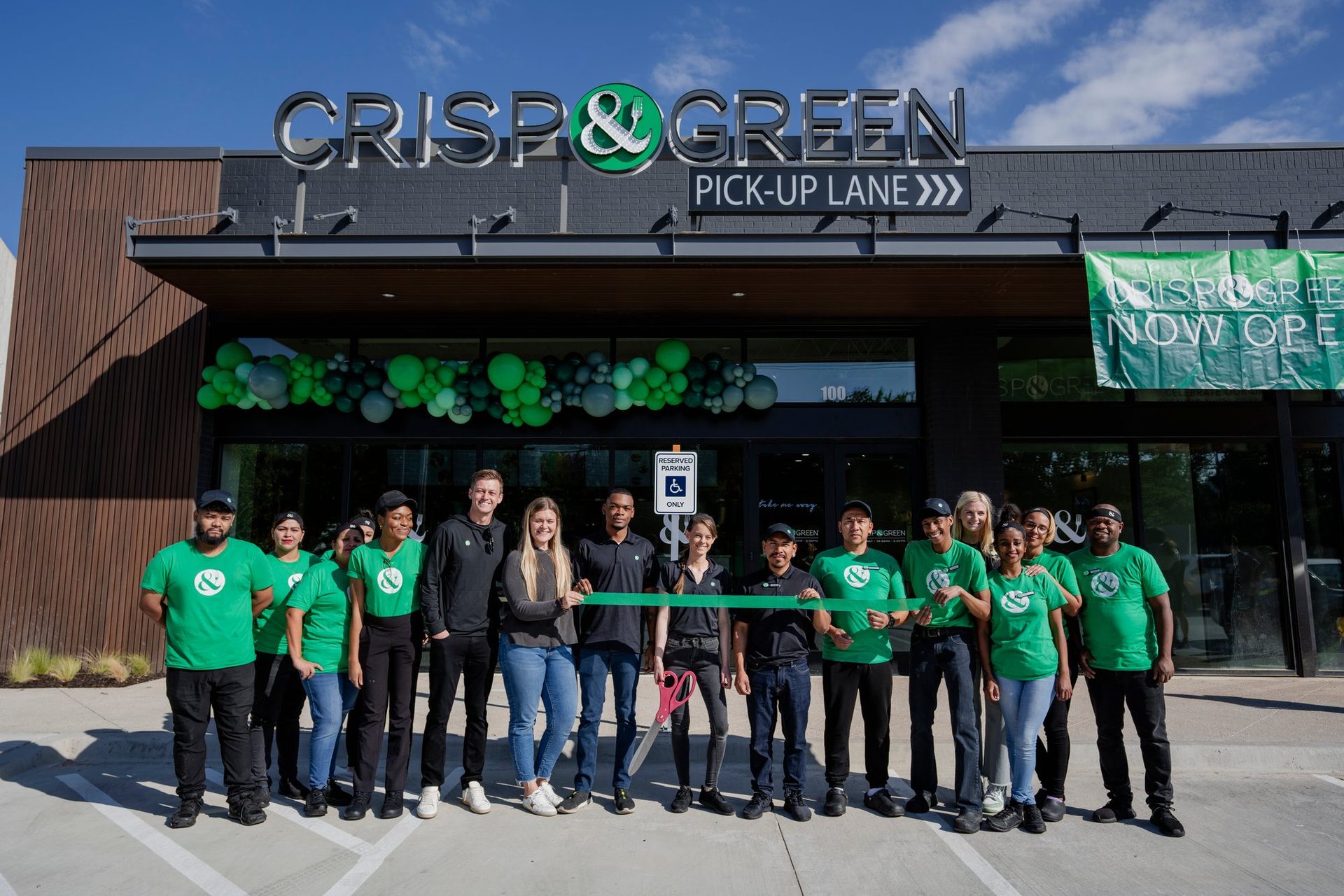 Crisp & Green team at the ribbon cutting in front of the Addison restaurant