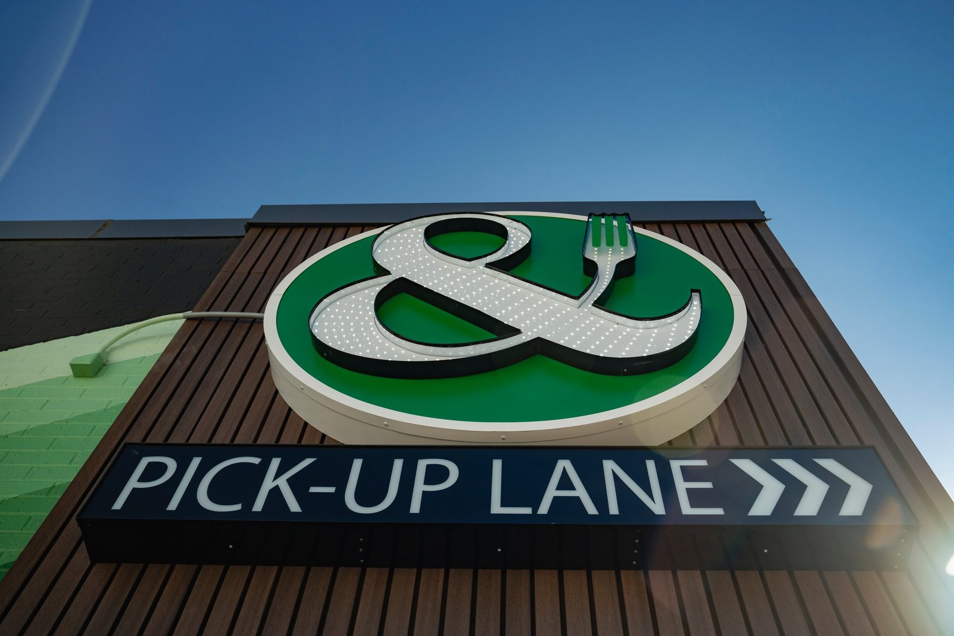 Crisp & Green pick-up lane sign against a blue sky