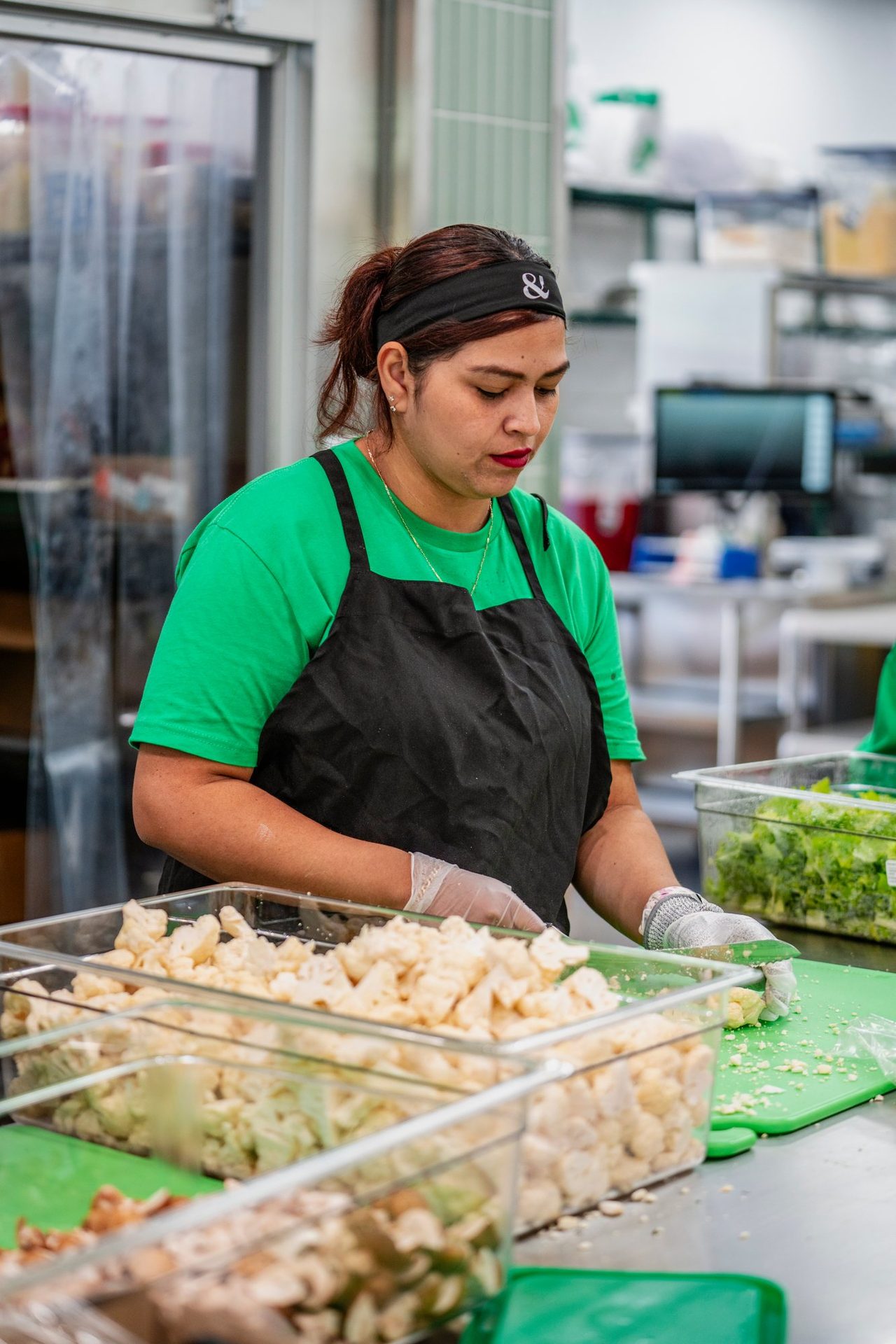 Team member prepping salad ingredients in the kitchen