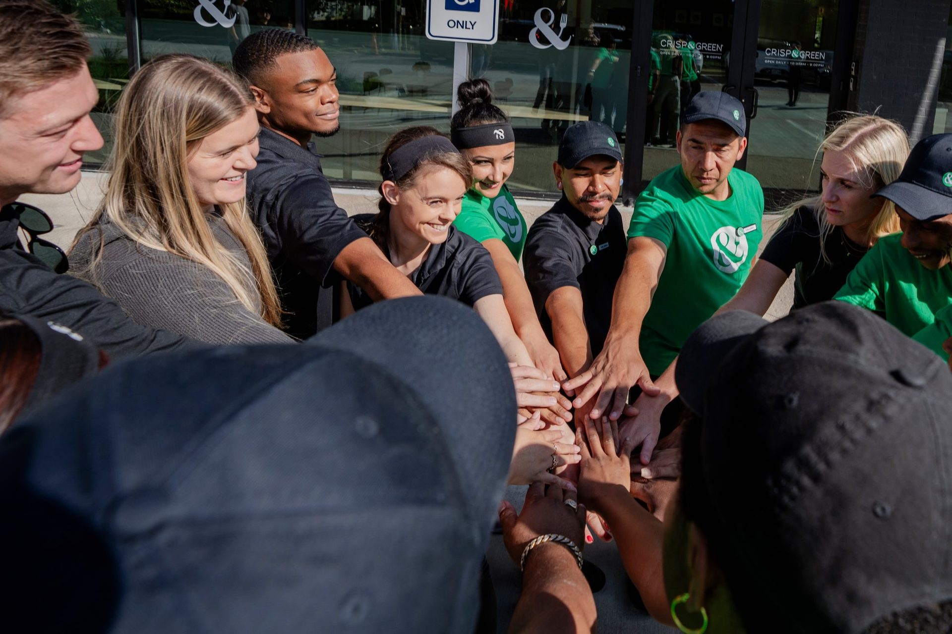 Team stacking hands in a huddle before opening