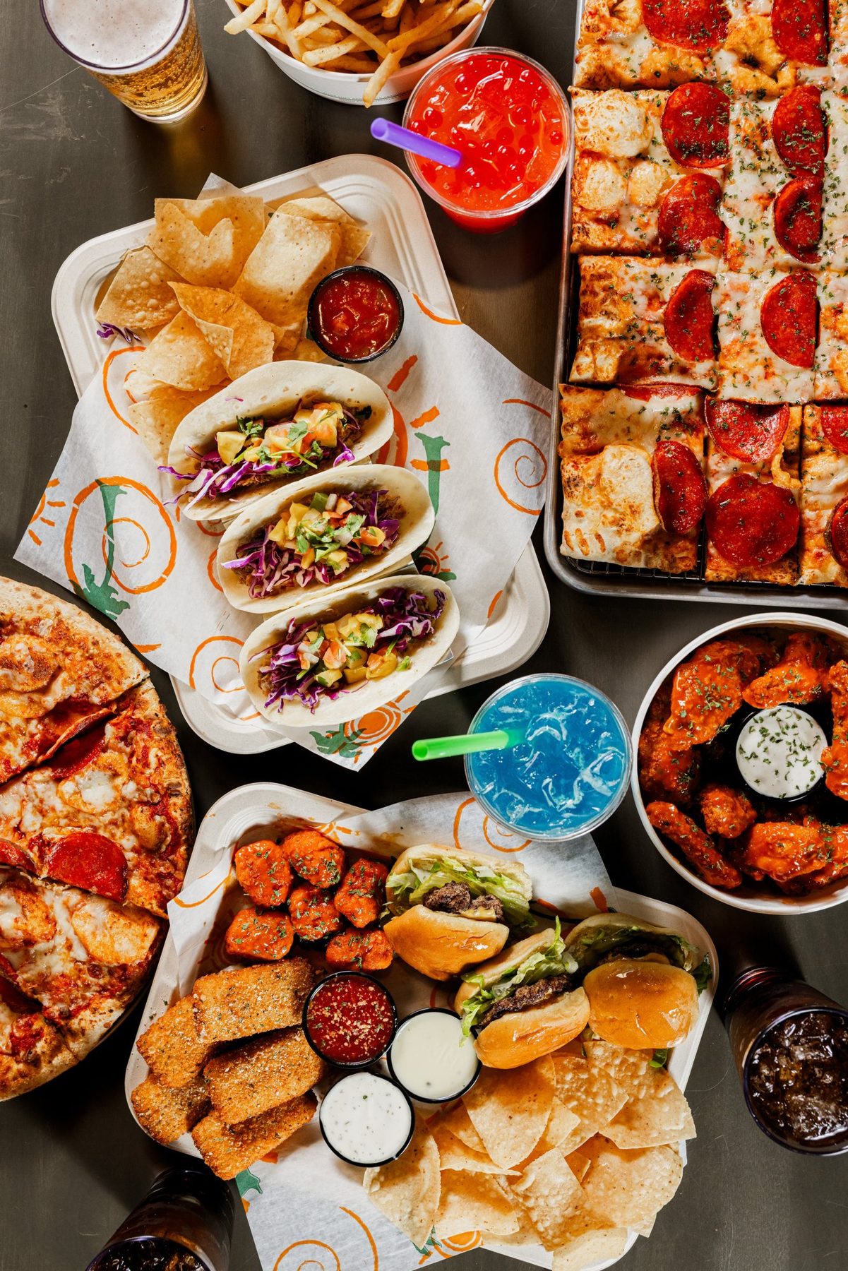Overhead spread of tacos, pizza, wings and drinks at Malibu Jack's