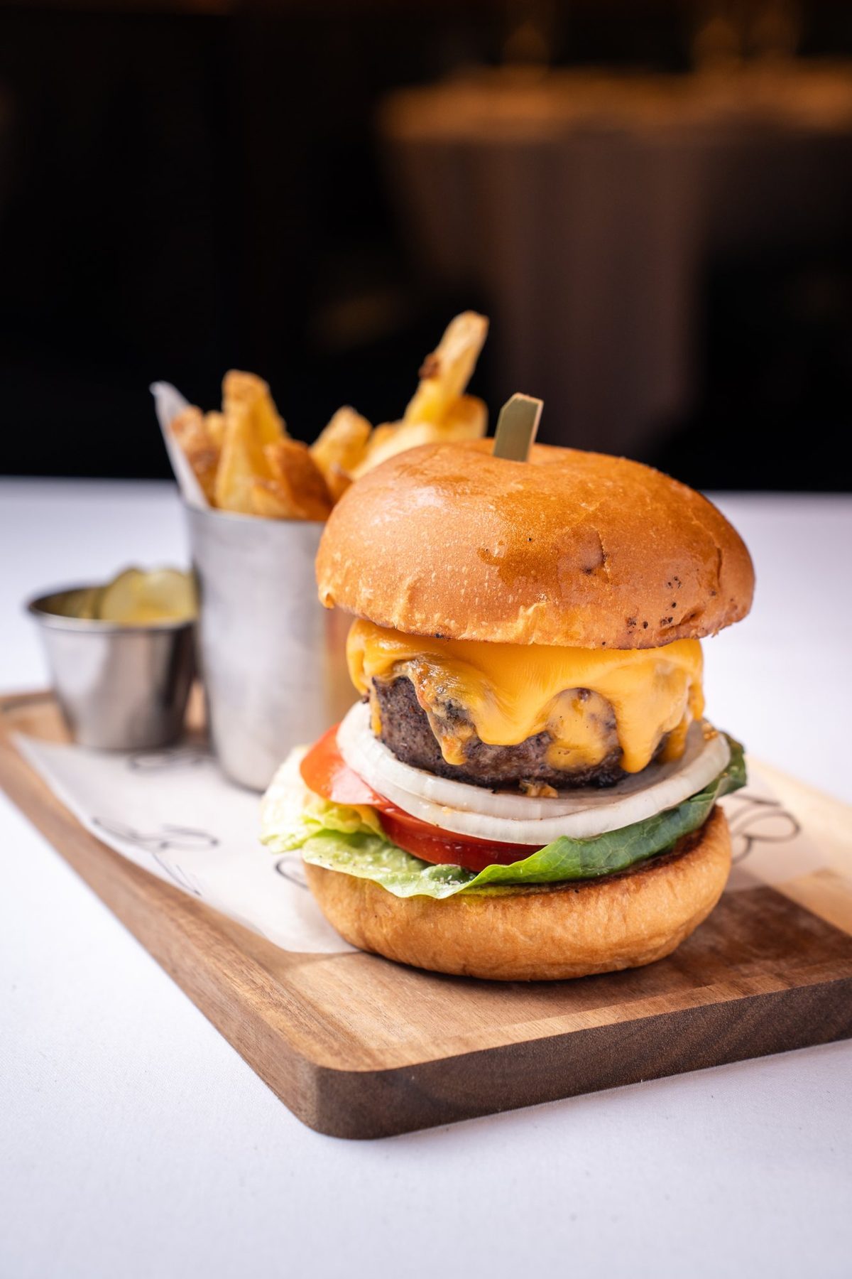 Cheeseburger and fries on a wooden board