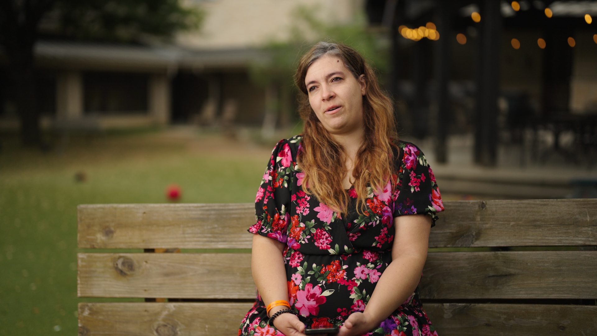 Mother seated in the courtyard at golden hour