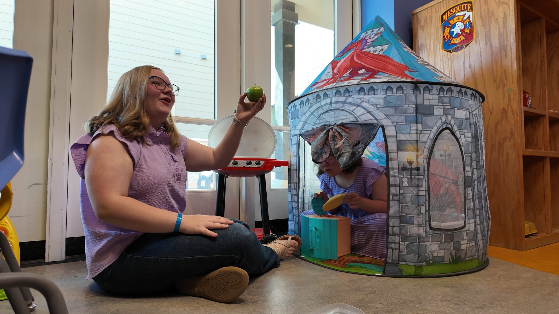 Mother and child playing by a castle tent in the family room