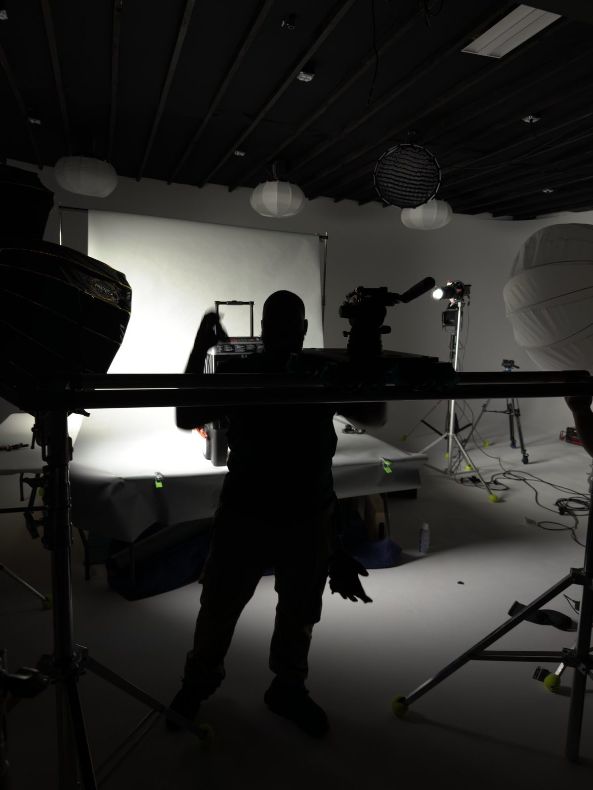 Silhouette of the crew adjusting lights on the Schumacher set