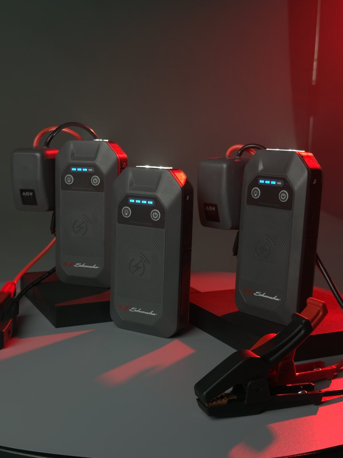 Schumacher lithium jump starters on a turntable under red light