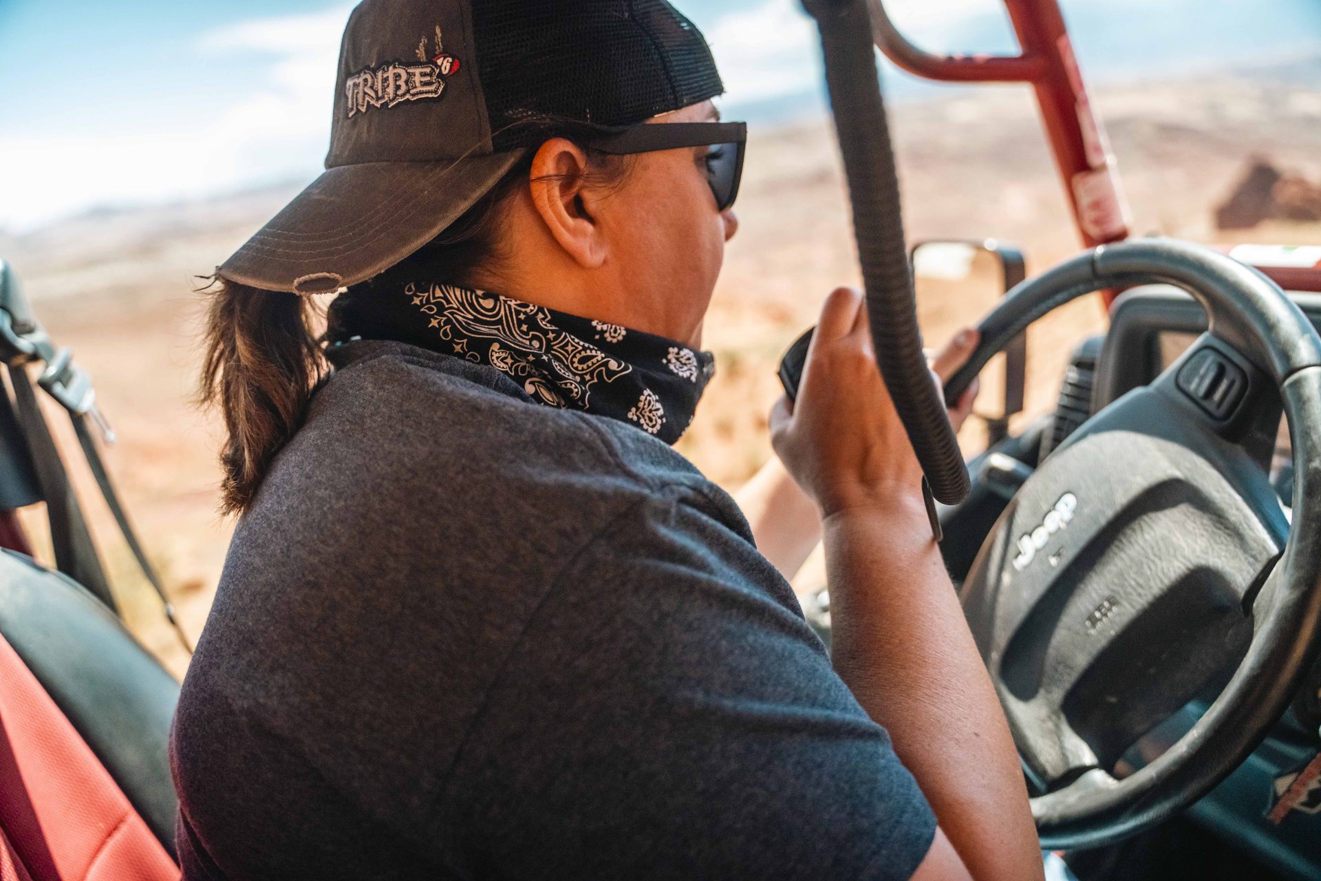Driver in a cap and bandana behind the wheel