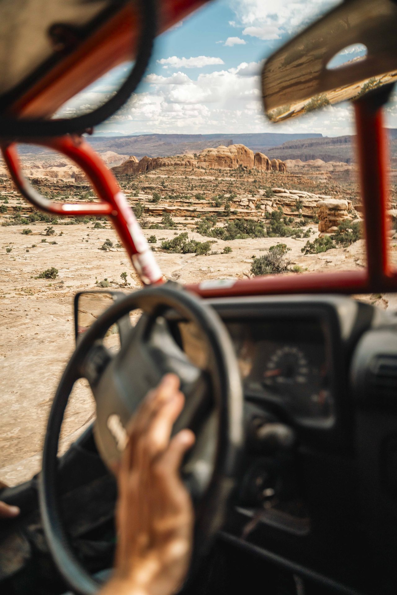 View over the steering wheel and roll cage toward the trail