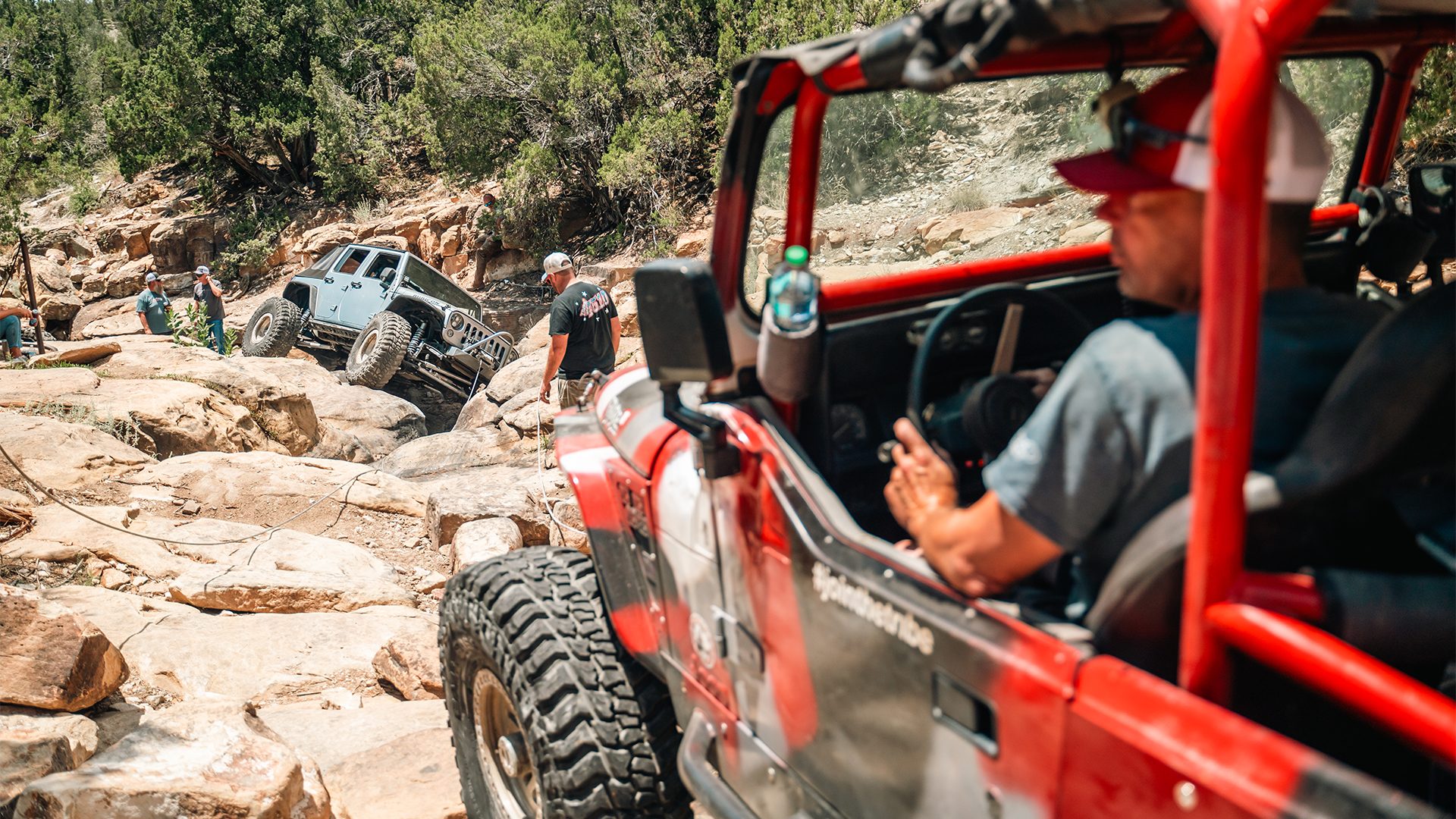 Driver in a red YJ Jeep on a rocky trail