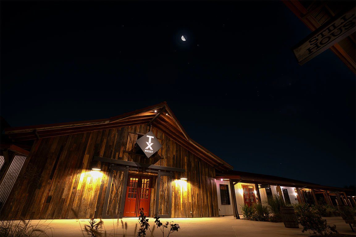 TX Whiskey Ranch distillery lit up at night