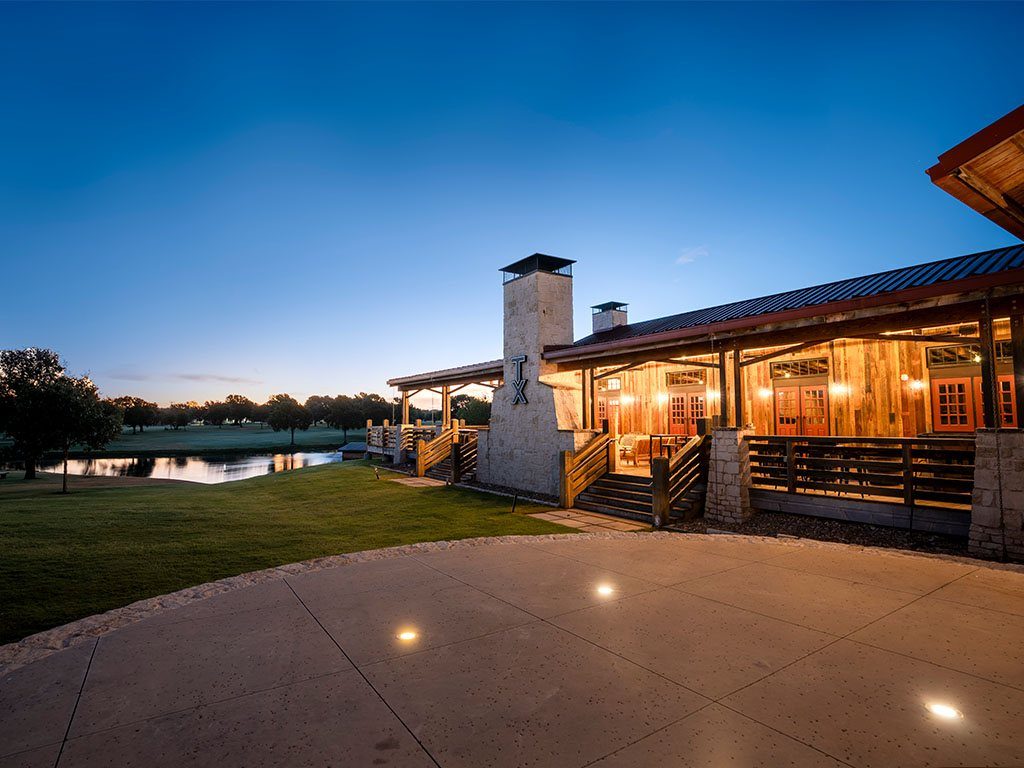 TX Whiskey Ranch porch and stone chimney at twilight