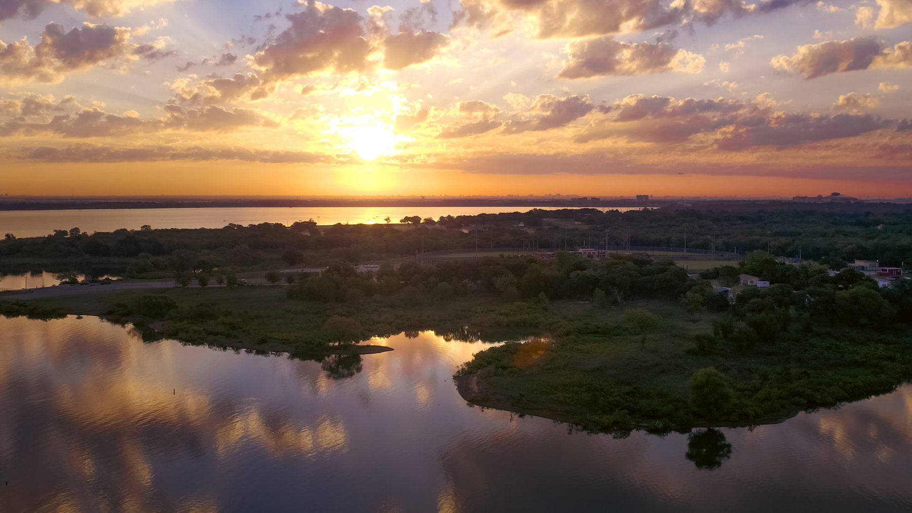 Drone view of a lake and wetlands at sunset