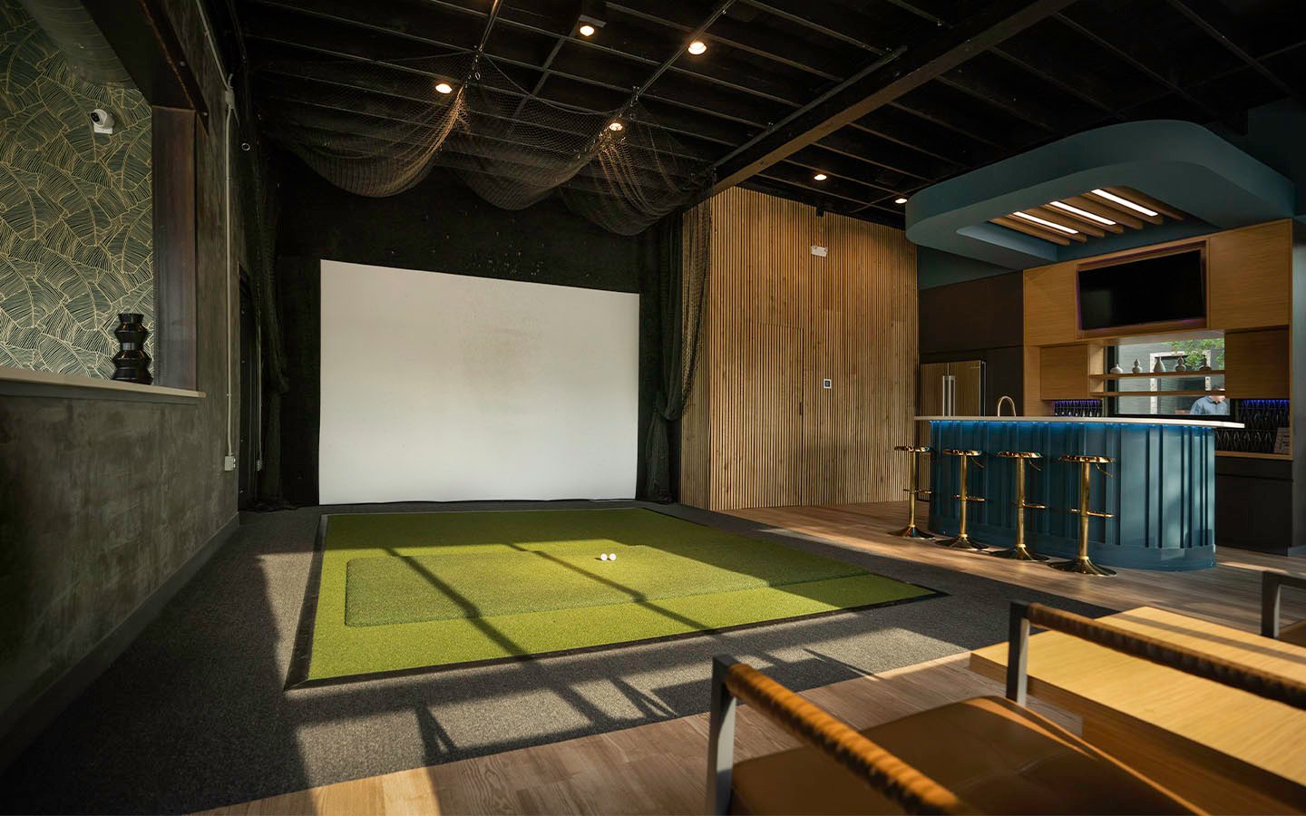 Golf simulator and bar inside the Valley Quest office