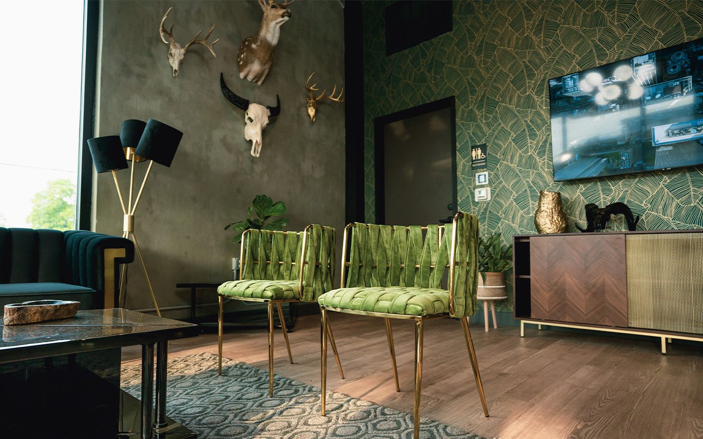 Valley Quest office lounge with green chairs and antler mounts