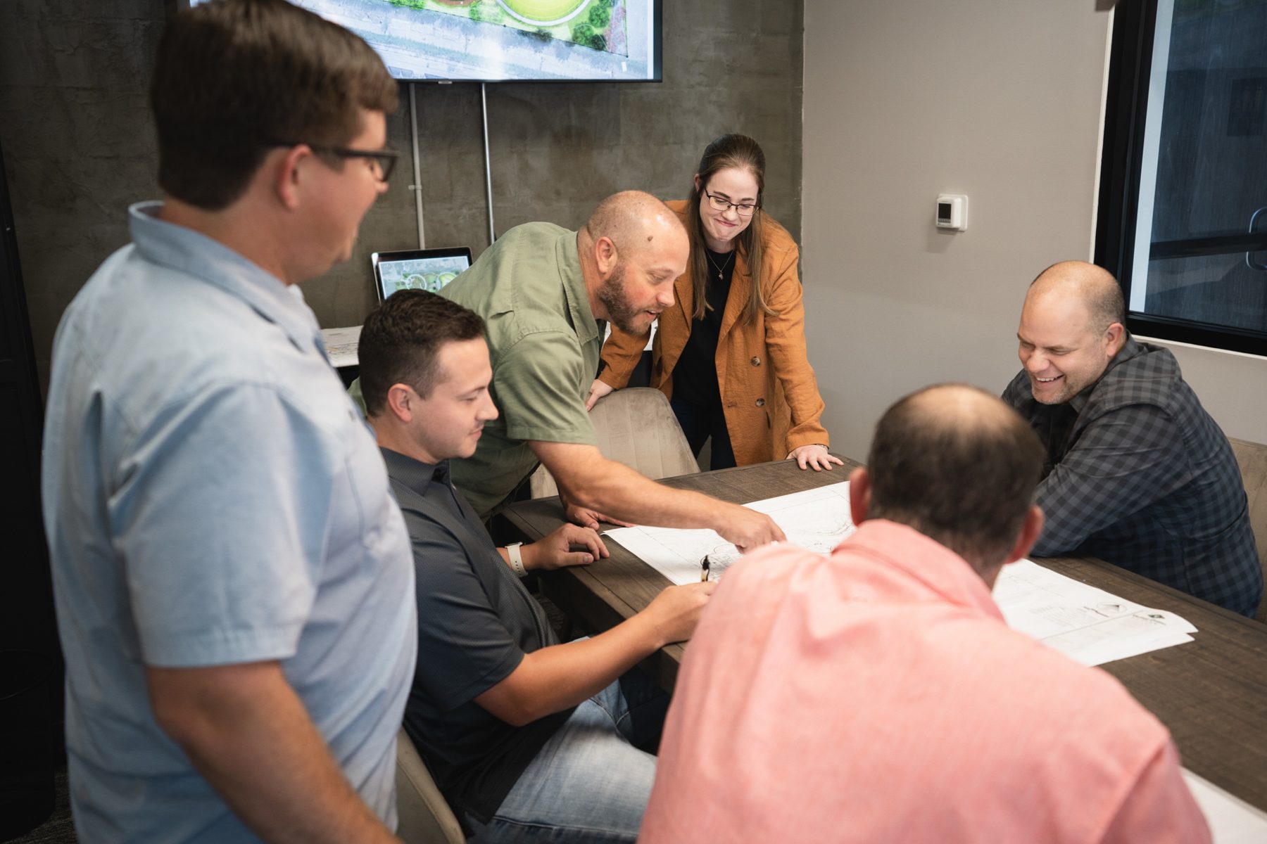 Valley Quest team laughing over plans in a design meeting