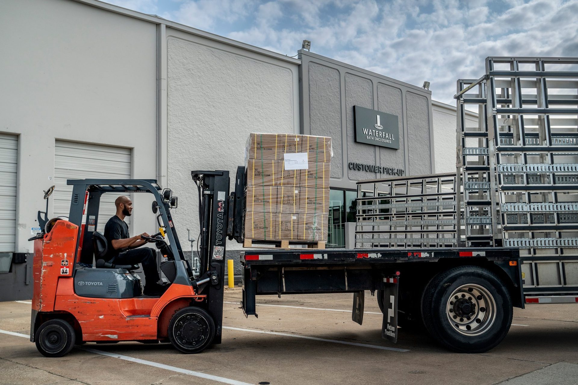 Forklift loading a glass rack truck outside the warehouse