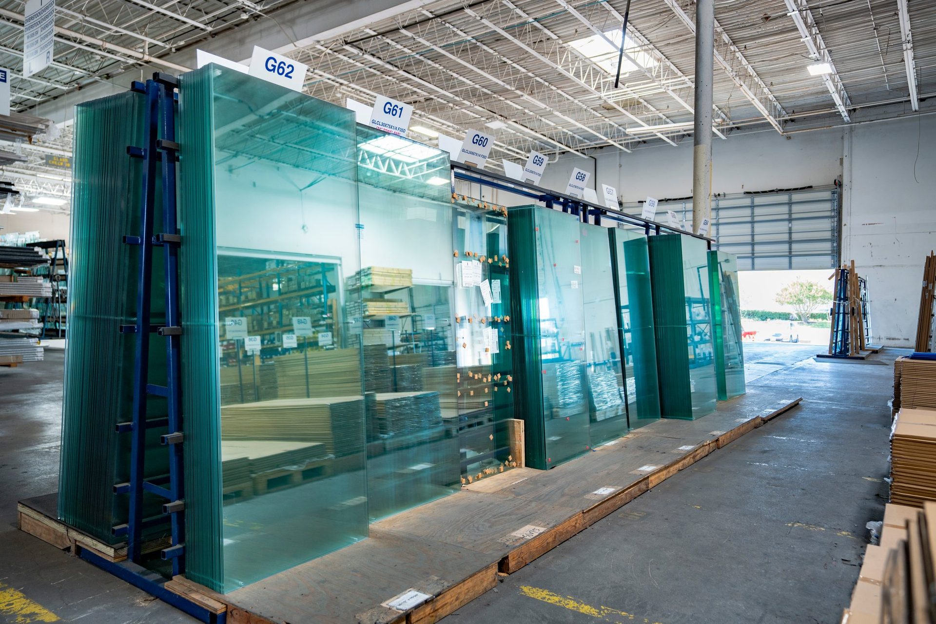 Green-edged sheets of shower glass on warehouse racks